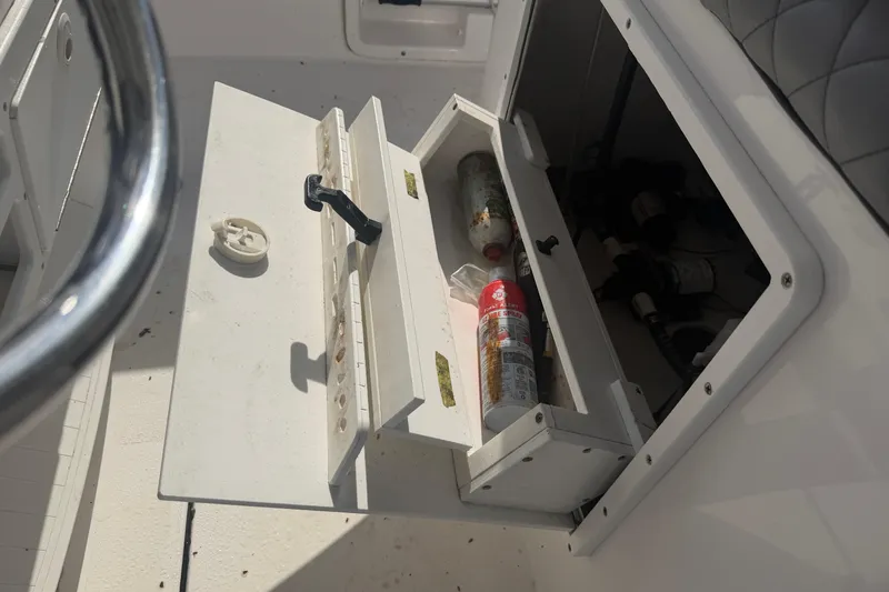 Slide: The Image of Open storage compartment on 2024 Clearwater 2800 boat with various items inside. - 28