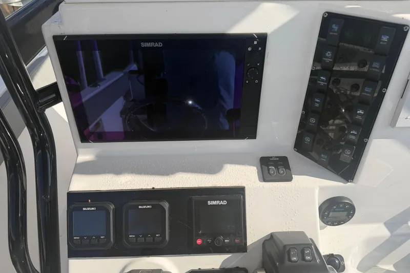Slide: The Image of 2024 Clearwater 2800 boat dashboard with Simrad and Suzuki displays. - 32