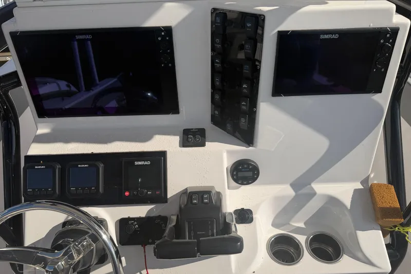 Slide: The Image of 2024 Clearwater 2800 boat dashboard with Simrad displays and controls. - 33