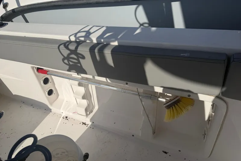Slide: The Image of 2024 Clearwater 2800 boat interior with storage compartment and cleaning brush. - 41