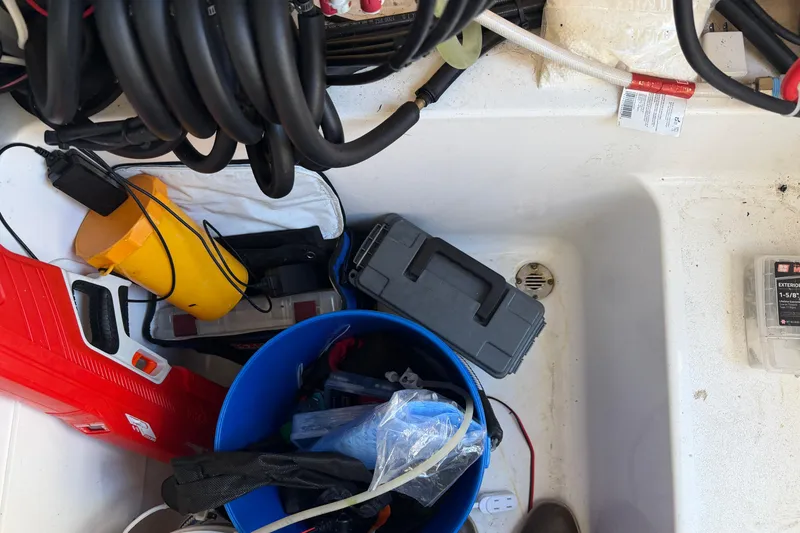 Slide: The Image of Storage compartment of a 2024 Clearwater 2800 boat with tools and equipment. - 58