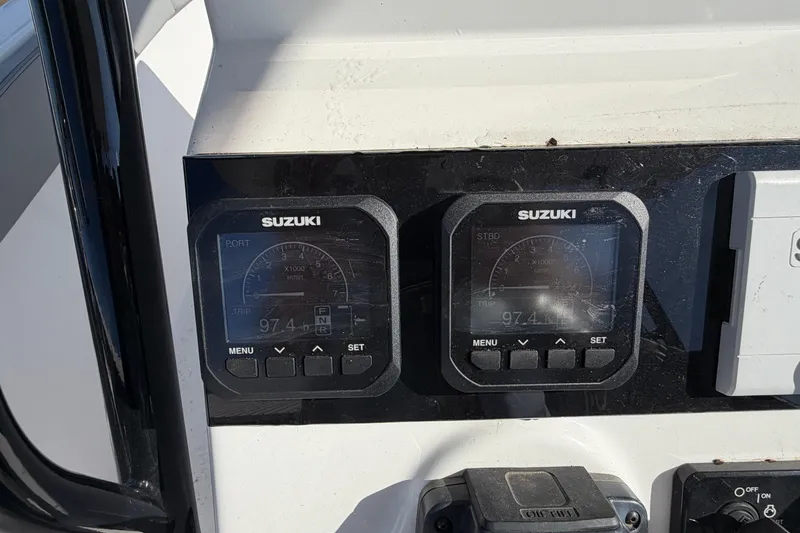 Slide: The Image of Suzuki digital gauges on a 2024 Clearwater 2800 boat dashboard. - 64