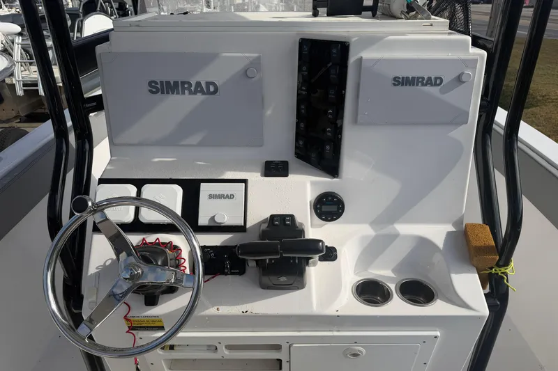 Slide: The Image of 2024 Clearwater 2800 boat dashboard with Simrad electronics and steering wheel. - 11