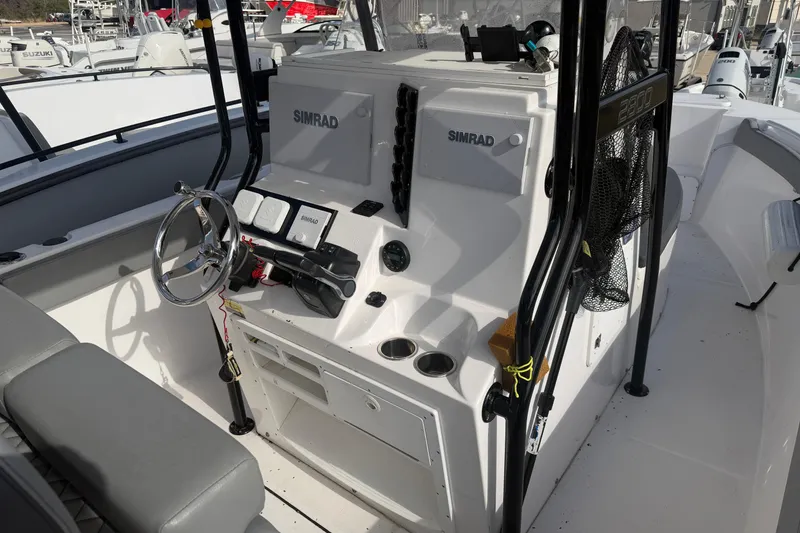 Slide: The Image of 2024 Clearwater 2800 boat cockpit with Simrad electronics and steering wheel. - 13