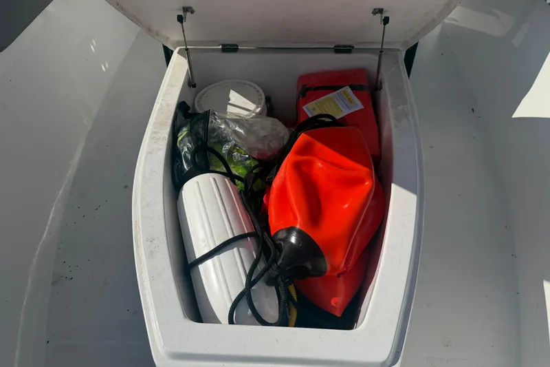 Slide: The Image of Open storage compartment on 2024 Clearwater 2800 boat with safety equipment. - 19