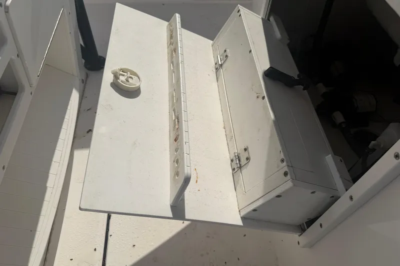 Slide: The Image of 2024 Clearwater 2800 boat storage compartment with open hatch and latch. - 29