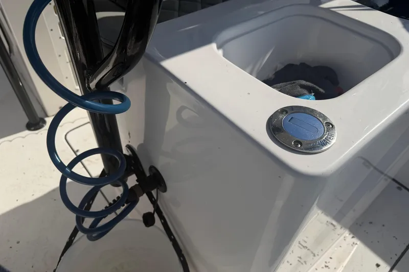 Slide: The Image of 2024 Clearwater 2800 boat detail with blue coiled hose and storage compartment. - 45