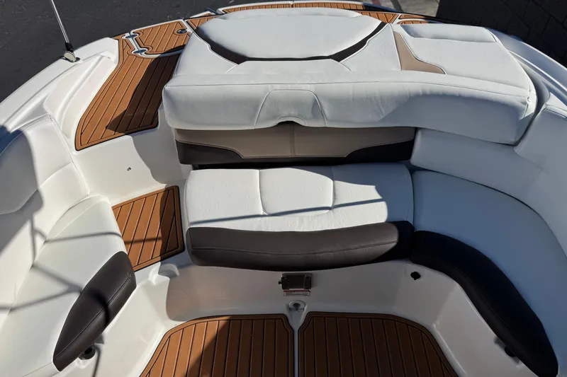 Slide: The Image of 2019 Monterey 224FS boat interior with white and brown seating, teak flooring. - 18