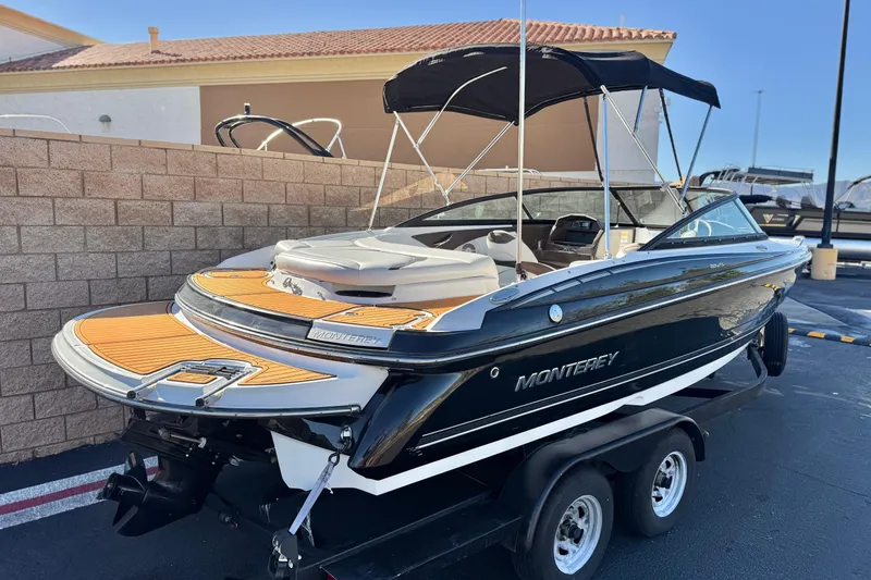 Slide: The Image of 2019 Monterey 224FS boat with black exterior and tan interior, parked on a trailer. - 5