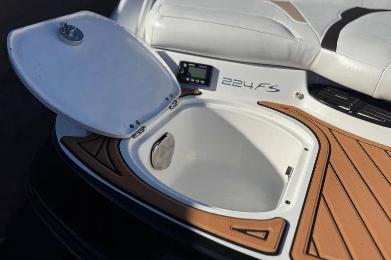 Slide: The Image of Open storage compartment on 2019 Monterey 224FS boat with cushioned seating. - 8