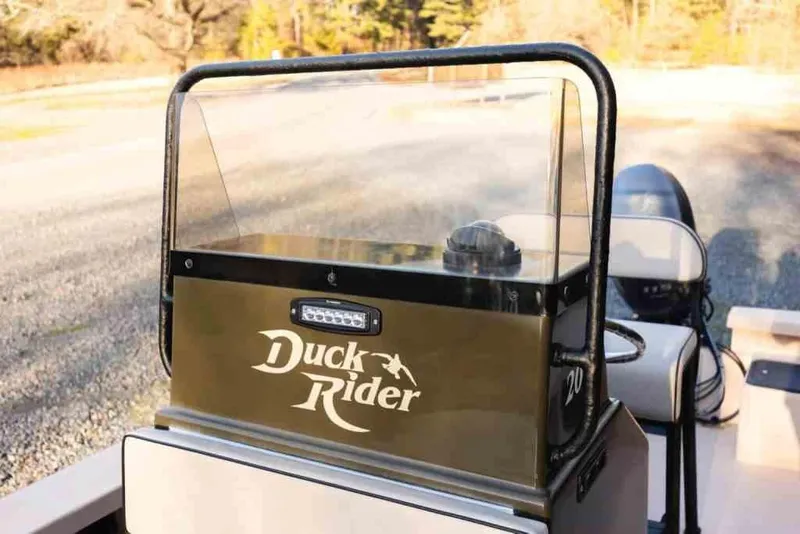 Slide: The Image of 2015 Bay Rider 2060 boat console with "Duck Rider" logo, outdoor setting. - 20