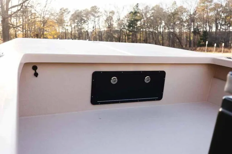 Slide: The Image of 2015 Bay Rider 2060 boat interior with storage compartment, surrounded by trees. - 25
