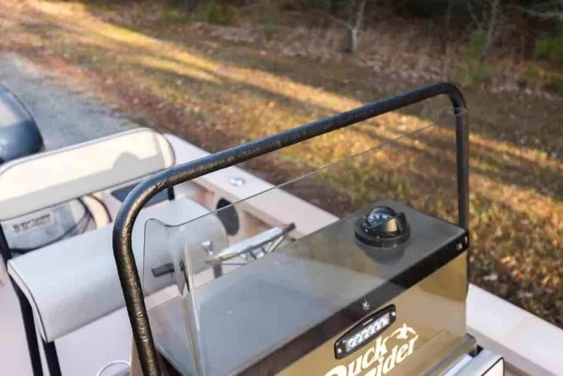 Slide: The Image of 2015 Bay Rider 2060 boat console with steering wheel and compass, parked on a dirt path. - 28