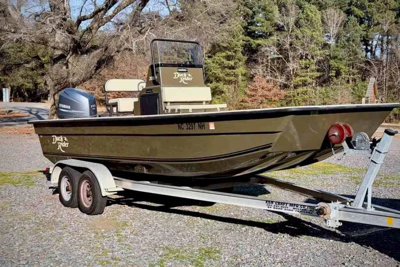 Slide: The Image of 2015 Bay Rider 2060 boat on trailer, parked outdoors with trees in background. - 3
