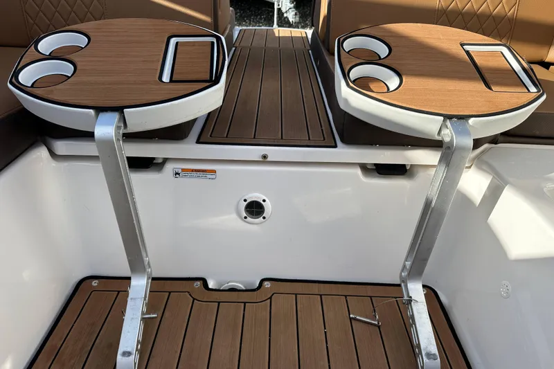 Slide: The Image of 2024 Yamaha Boats 252SE interior with dual cupholder tables and teak flooring. - 18