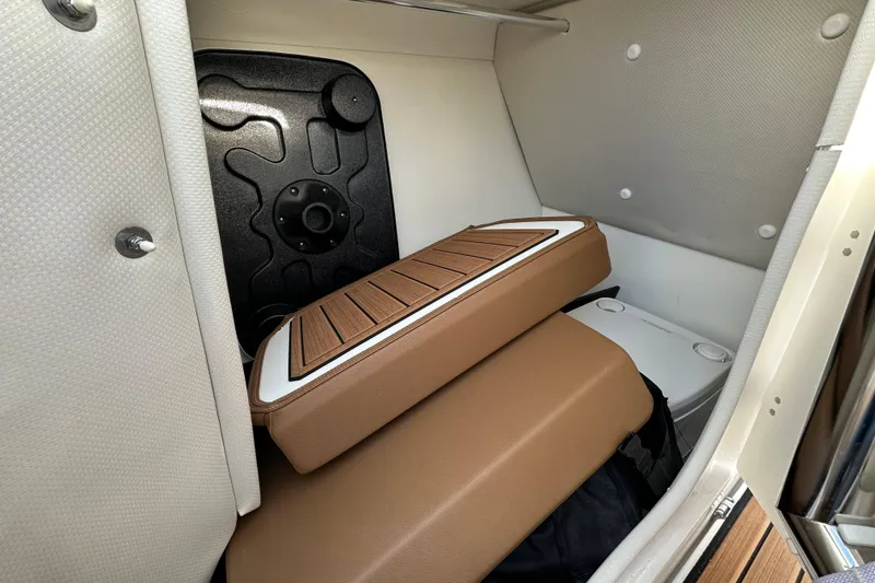 Slide: The Image of 2024 Yamaha Boats 252SE interior storage with cushioned seating and compact design. - 20