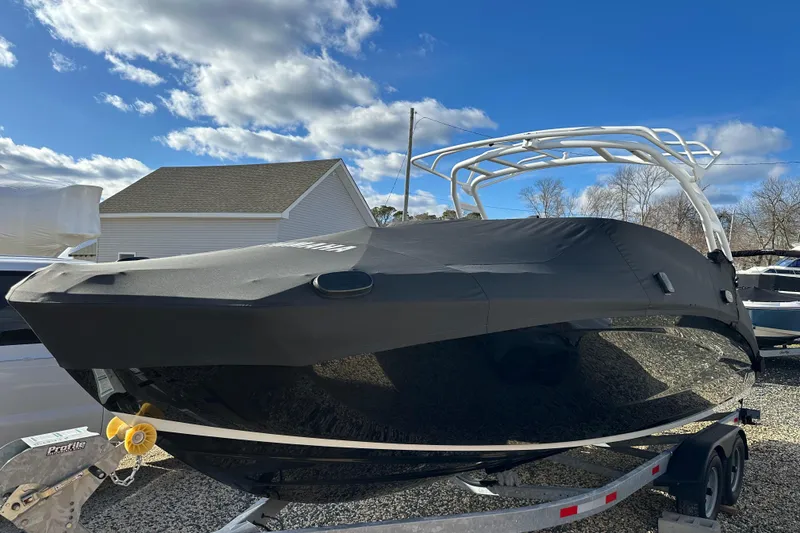Slide: The Image of 2024 Yamaha Boats 252SE covered on trailer under blue sky. - 21
