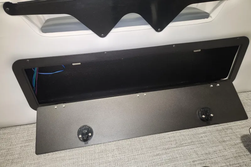 Slide: The Image of 2026 Tahoe Pontoon 23 LTZ Rear Bench storage compartment with open lid and visible wiring. - 115