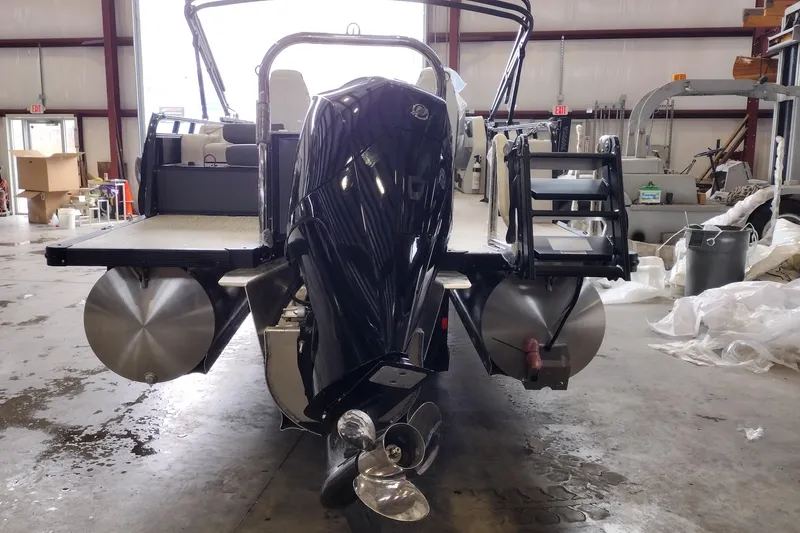 Slide: The Image of 2026 Tahoe Pontoon 25E85 LTZ Rear Bench in a warehouse, showcasing rear view and motor. - 121