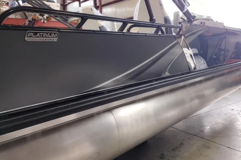 Slide: The Image of 2026 Tahoe Pontoon 25E85 LTZ Rear Bench, Platinum Edition, sleek design in a showroom. - 128