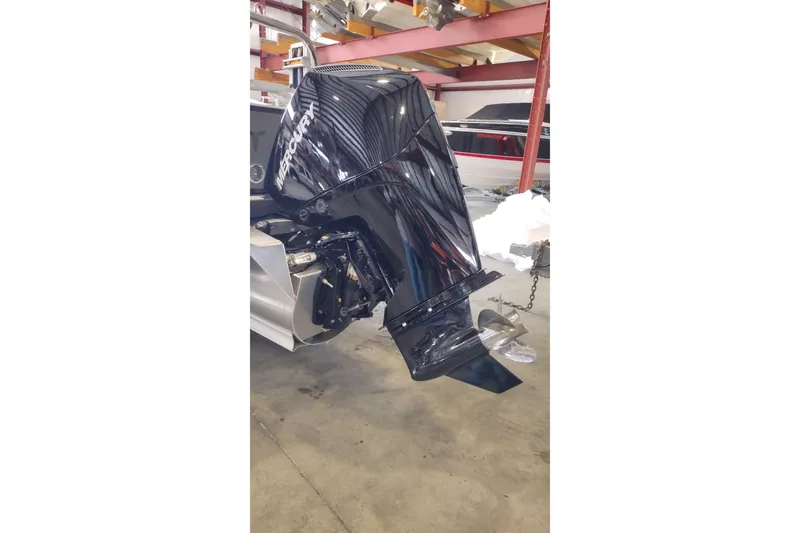 Slide: The Image of 2026 Tahoe Pontoon 25E85 LTZ Rear Bench with Mercury outboard motor in a workshop. - 129