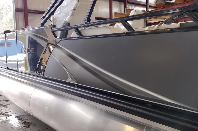 Slide: The Image of 2026 Tahoe Pontoon 23 LTZ Rear Bench with illuminated LED lights in a showroom. - 87