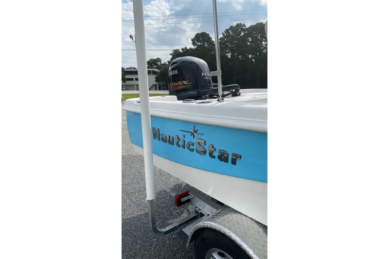 Slide: The Image of 2022 NauticStar 195 XTS boat on trailer under sunny sky. - 11