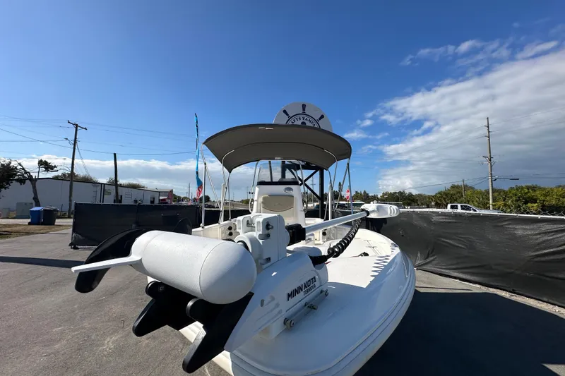 Slide: The Image of 2022 NauticStar 195 XTS boat with Minn Kota trolling motor, parked outdoors under clear sky. - 16