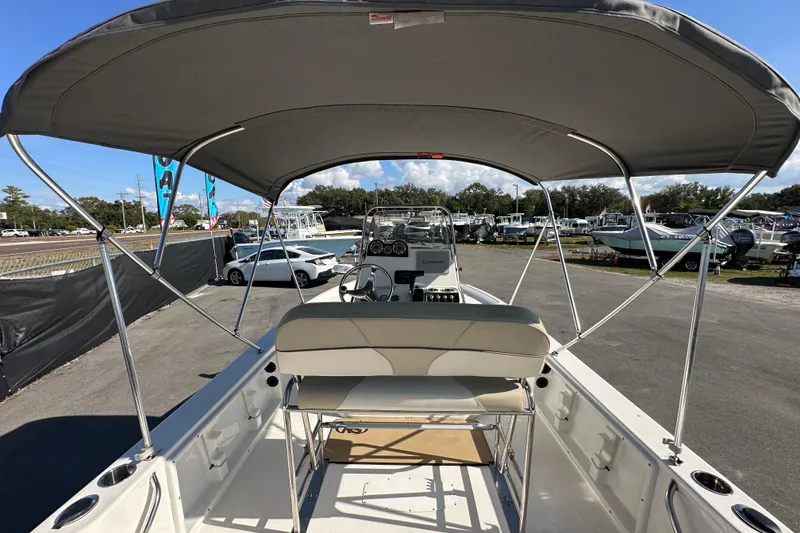 Slide: The Image of 2022 NauticStar 195 XTS boat with canopy, parked in a dealership lot. - 21