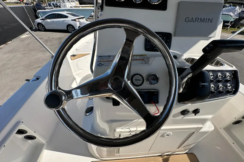 Slide: The Image of Steering wheel and controls of 2022 NauticStar 195 XTS boat, featuring Garmin system. - 25