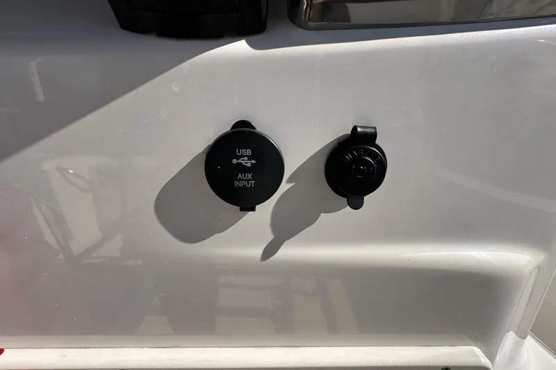 Slide: The Image of 2022 NauticStar 195 XTS USB and auxiliary input ports on boat console. - 36