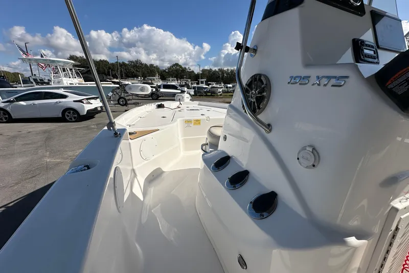 Slide: The Image of 2022 NauticStar 195 XTS boat interior with console and seating, parked outdoors. - 42