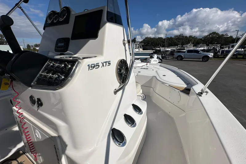 Slide: The Image of 2022 NauticStar 195 XTS boat interior with console and seating, under a clear blue sky. - 44