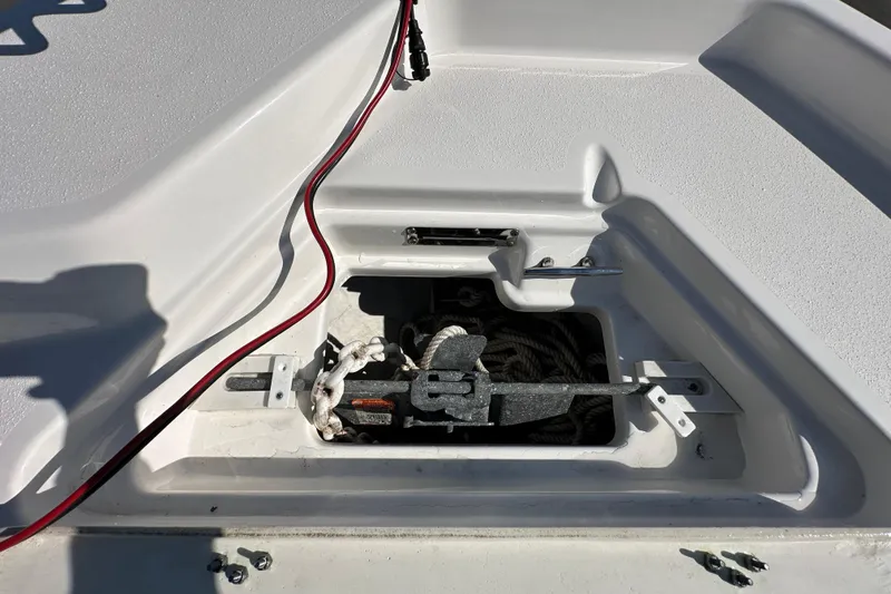 Slide: The Image of 2022 NauticStar 195 XTS anchor compartment with red cable and anchor storage. - 56