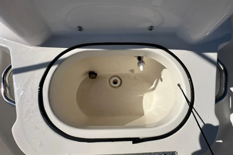 Slide: The Image of Livewell compartment of 2022 NauticStar 195 XTS boat, featuring drainage and hose. - 69