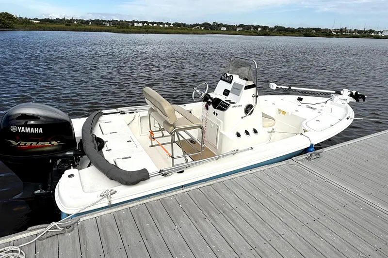 Slide: The Image of 2022 NauticStar 195 XTS boat with Yamaha VMAX engine, parked outdoors under blue sky. - 9