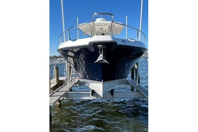 The Image of 2006 Century 3200 Center Console boat on lift, docked by the water. - 0