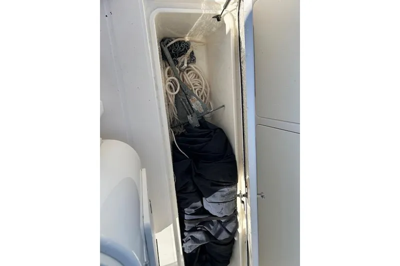 Slide: The Image of Storage compartment in a 2006 Century 3200 Center Console boat with ropes and gear. - 19