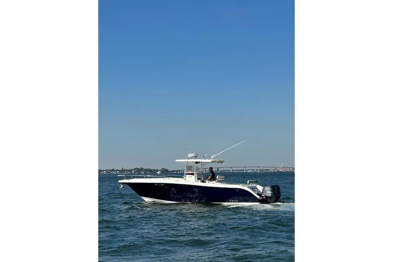 Slide: The Image of 2006 Century 3200 Center Console boat cruising on open water under clear blue sky. - 2