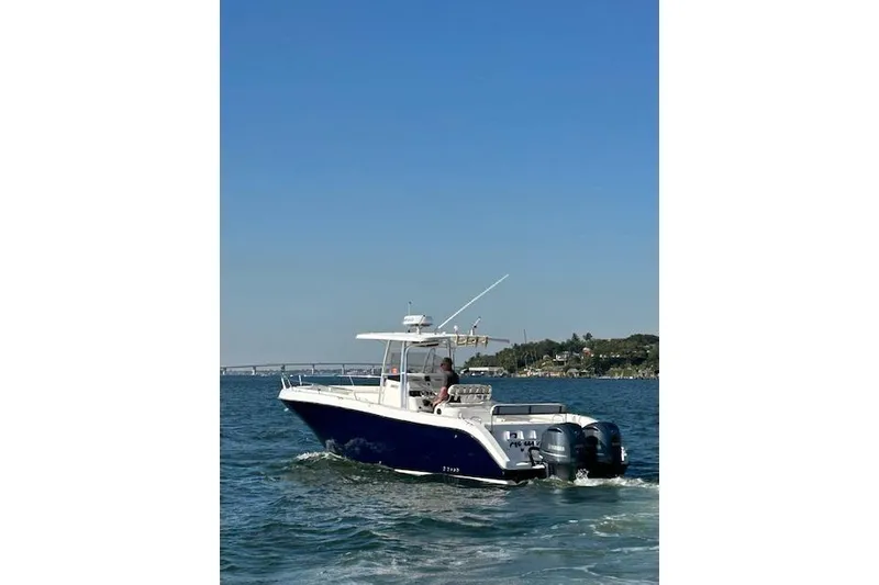 Slide: The Image of 2006 Century 3200 Center Console boat cruising on open water under clear blue sky. - 3