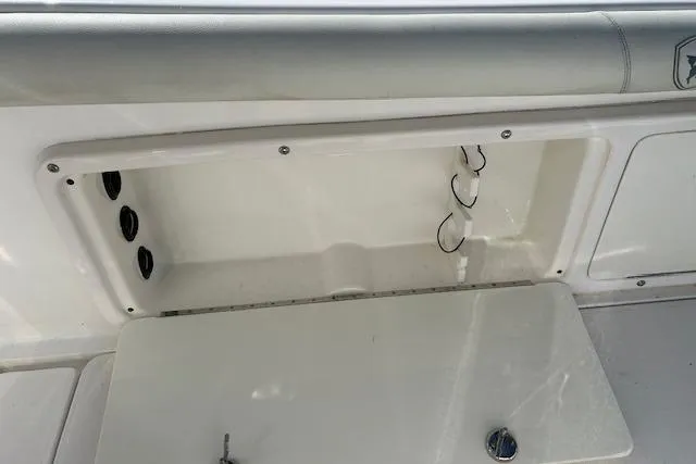 Slide: The Image of 2006 Century 3200 Center Console storage compartment with open hatch and visible wiring. - 30