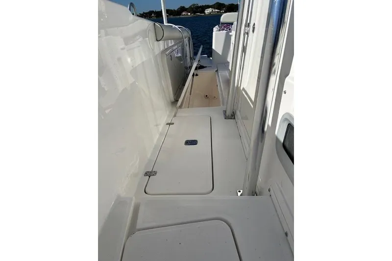 Slide: The Image of 2006 Century 3200 Center Console boat deck with storage compartments, near water. - 32