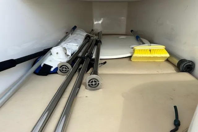 Slide: The Image of Storage compartment in a 2006 Century 3200 Center Console boat with cleaning tools. - 41