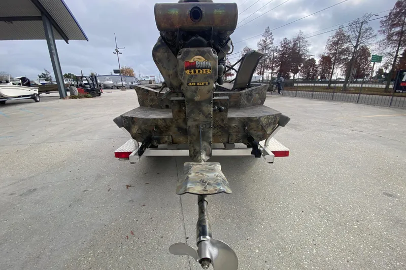 Slide: The Image of 2023 Excel F86 boat with Mud Buddy HDR 40 EFI motor in a parking lot. - 4