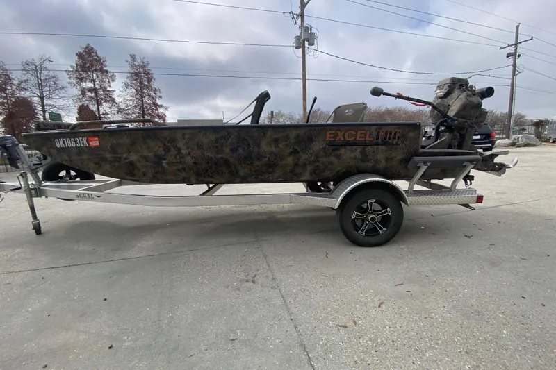 Slide: The Image of 2023 Excel F86 boat on trailer, camo design, parked outdoors. - 6