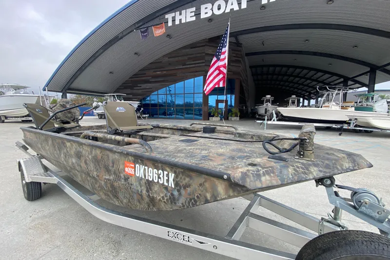 Slide: The Image of 2023 Excel F86 boat with camouflage design on a trailer outside a boat dealership. - 9