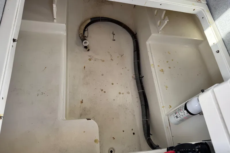 Slide: The Image of Open storage compartment of 2001 Sport-Craft 260 Center Console boat with hose and fire extinguisher. - 18