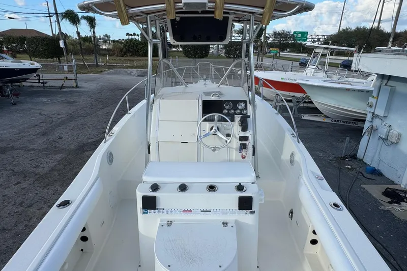 Slide: The Image of 2001 Sport-Craft 260 Center Console boat with steering wheel and control panel, docked outdoors. - 4