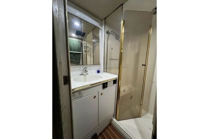 Slide: The Image of 1996 Ocean Yachts 48 Super Sport interior with docked view, featuring white seating and marina backdrop. - 43