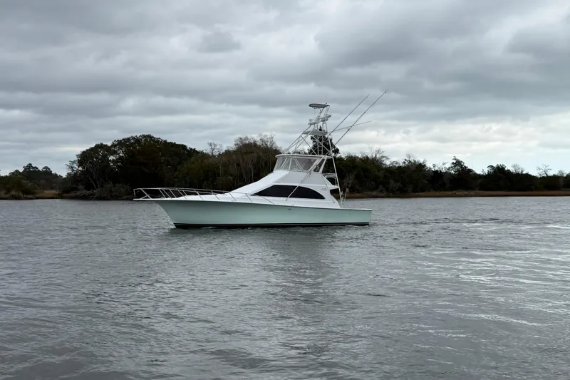 Slide: The Image of 1996 Ocean Yachts 48 Super Sport cruising in a marina, surrounded by other boats. - 59